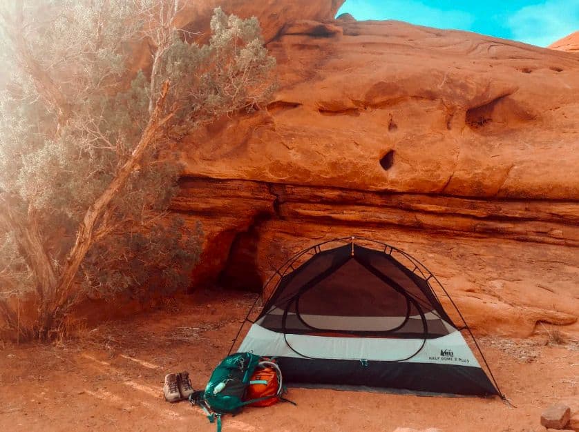 A tent pitched in the shelter of a large rock